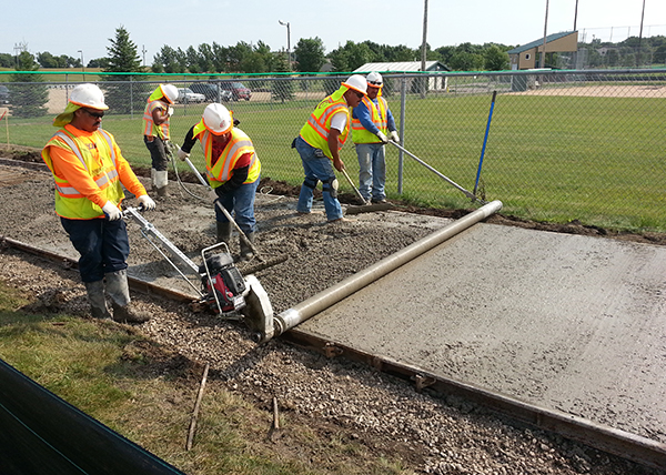 Crews work with wet concrete on a sidewalk in Pipestone, Minnesota.